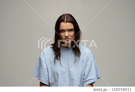 Young woman feeling frustrated, annoyed, and grumpy, expressing emotion with a skeptical, angry facial grimace 138559811