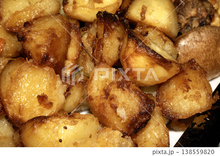 Close up of roasted vegetables crsipy potatoes side dish for Sunday roast dinner Close up of roasted vegetables crsipy potatoes side dish for Sunday roast dinner 138559820