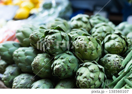 Pile of artichokes displayed on market counter Pile of artichokes displayed on market counter 138560107