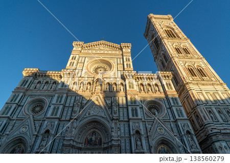 A low-angle view of the Florence Cathedral's facade and Giotto's Campanile under a clear blue sky 138560279