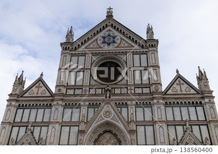 The ornate facade of the Basilica di Santa Croce, a masterpiece of Italian Gothic and Renaissance design, stands against a cloudy sky The ornate facade of the Basilica di Santa Croce, a masterpiece of Italian Gothic and Renaissance design, stands against a cloudy sky 138560400