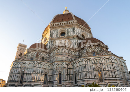 The iconic Duomo of Florence, Italy, showcases its intricate Renaissance architecture and terracotta dome against a clear blue sky 138560405