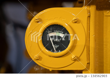 Vintage Tractor Fuel Gauge Close-Up on Yellow Industrial Panel Vintage Tractor Fuel Gauge Close-Up on Yellow Industrial Panel 138562903