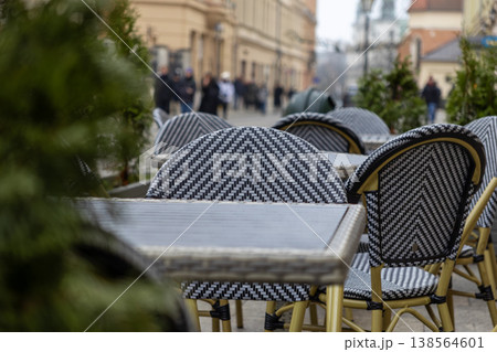 Distinctive outdoor cafe chairs and tables with a stylish black and white chevron pattern on a European city street, highlighting urban hospitality and local charm 138564601