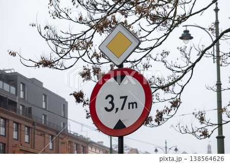 Urban street signs featuring a 3,7m height restriction and a prominent priority road symbol, ensuring safe traffic flow in the city Urban street signs featuring a 3,7m height restriction and a prominent priority road symbol, ensuring safe traffic flow in the city 138564626
