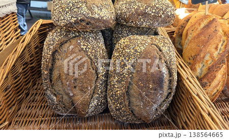 Whole grain seeded loaves in wicker basket at farmers market for bakery poster and rustic food background Whole grain seeded loaves in wicker basket at farmers market for bakery poster and rustic food background 138564665