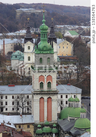 The Korniakt Tower and Dormition Church in Lviv with historic city architecture and hills, Ukraine 138564763