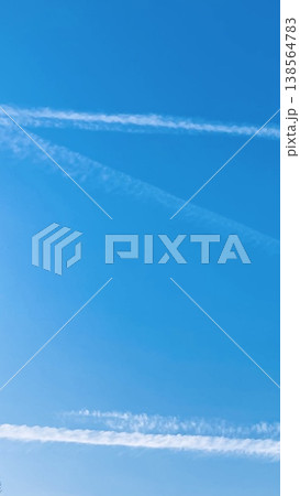 青空と飛行機雲の縦長背景素材（スマホ・動画・コピースペース） 138564783