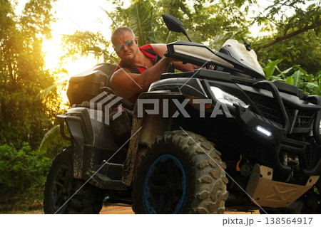 A man engages in extreme ATV riding on mountains in the evening A man engages in extreme ATV riding on mountains in the evening 138564917