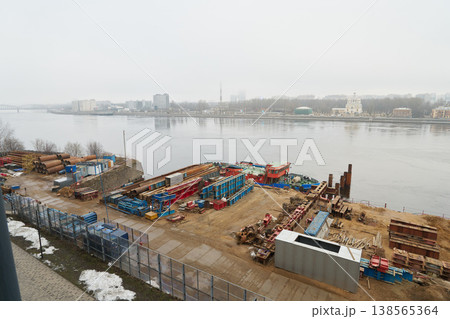 Busy riverfront area featuring vessels and continuous logistical tasks 138565364
