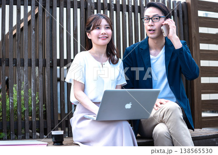 リモートワーク中に屋外でコーヒーを飲みながら会話を楽しむ若い男女 リモートワーク中に屋外でコーヒーを飲みながら会話を楽しむ若い男女 138565530