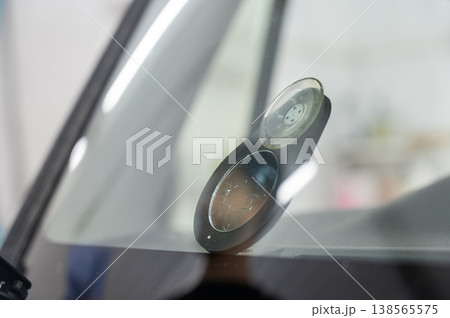 Repairing a chip on a car windshield. Repairing a chip on a car windshield. 138565575