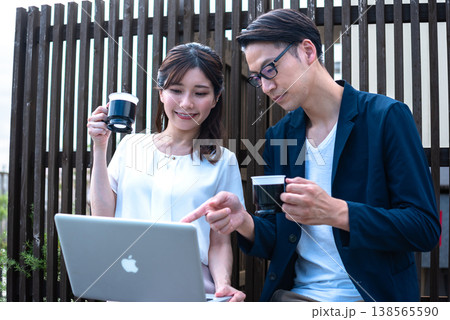 リモートワーク中に屋外でコーヒーを飲みながら会話を楽しむ若い男女 リモートワーク中に屋外でコーヒーを飲みながら会話を楽しむ若い男女 138565590