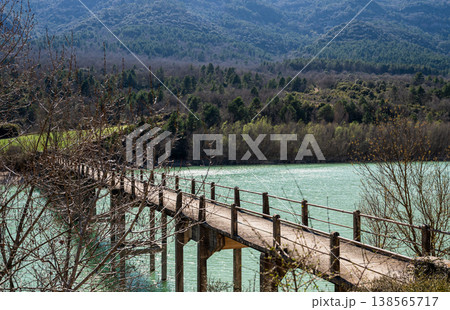 Wooden bridge over turquoise lake with forest and mountains in Spain scenic nature landscape 138565717