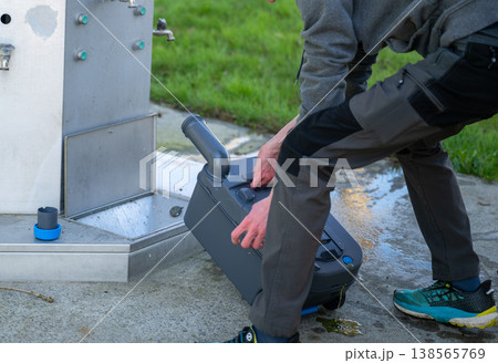 Man emptying portable toilet cassette at camper service station RV sanitation waste disposal concept Man emptying portable toilet cassette at camper service station RV sanitation waste disposal concept 138565769