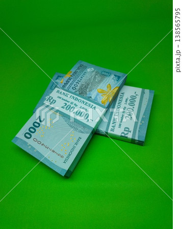 Green background holds neatly stacked banknotes. Stacks show denominations, clear and crisp. Ideal for financial, business, or economic imagery needs. No people, no animals, no plants visible here Green background holds neatly stacked banknotes. Stacks show denominations, clear and crisp. Ideal for financial, business, or economic imagery needs. No people, no animals, no plants visible here 138565795
