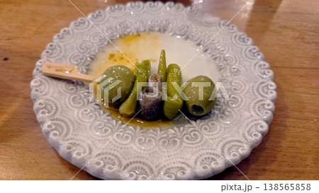 Skewered green olives with anchovy and pickled pepper on decorative ceramic plate for spanish tapas appetizer and bar snack presentation. Gilda, spanish tapas Skewered green olives with anchovy and pickled pepper on decorative ceramic plate for spanish tapas appetizer and bar snack presentation. Gilda, spanish tapas 138565858