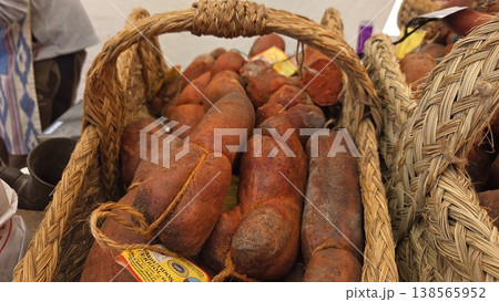 Rustic basket of cured sausages and chorizo at a spanish farmers market for food display and gourmet banner design Rustic basket of cured sausages and chorizo at a spanish farmers market for food display and gourmet banner design 138565952