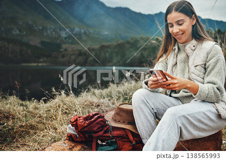 Nature, smile and woman on a phone for hiking on a mountain and network on social media or mobile app. Happy, technology and young female person scroll on internet with cellphone in outdoor forest. Nature, smile and woman on a phone for hiking on a mountain and network on social media or mobile app. Happy, technology and young female person scroll on internet with cellphone in outdoor forest. 138565993