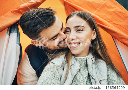 Happy couple, kiss and tent for camping, holiday or outdoor vacation together in affection, bonding or nature. Face of man kissing woman with smile on camp site for travel, love or trip in adventure Happy couple, kiss and tent for camping, holiday or outdoor vacation together in affection, bonding or nature. Face of man kissing woman with smile on camp site for travel, love or trip in adventure 138565999