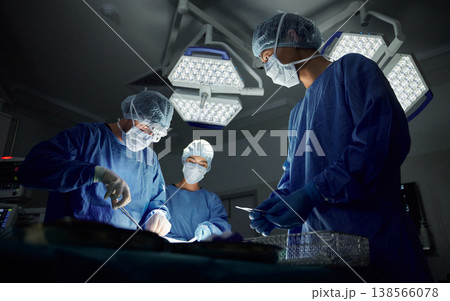 Teamwork, emergency and doctors or people in surgery procedure or healthcare operation in hospital. Night, low angle or surgeon in face mask or gloves help in dark operating room in medical clinic Teamwork, emergency and doctors or people in surgery procedure or healthcare operation in hospital. Night, low angle or surgeon in face mask or gloves help in dark operating room in medical clinic 138566078