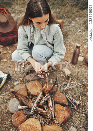 Wood, nature and woman with fire on a camp on a mountain for adventure, weekend trip or vacation. Stone, sticks and young female person making a flame or spark in outdoor woods or forest for holiday. Wood, nature and woman with fire on a camp on a mountain for adventure, weekend trip or vacation. Stone, sticks and young female person making a flame or spark in outdoor woods or forest for holiday. 138566092