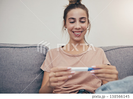 Pregnancy test, happy and woman on sofa in home, reading good news and check positive results. Stick, smile and pregnant mother in living room excited for success, future maternity and ivf fertility 138566145
