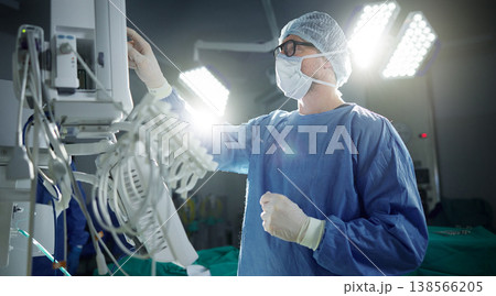 Healthcare, monitor and vital with a doctor in theater getting ready for surgery in a hospital operating room. Medical, technology and equipment with a surgeon in a clinic as a medicine professional 138566205