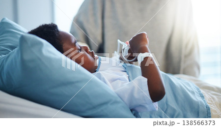 Sick black kid in hospital at bed for healthcare, recovery from virus or healing injury in pediatric clinic. Disease, illness and African child resting or patient in bedroom in medical rehabilitation 138566373