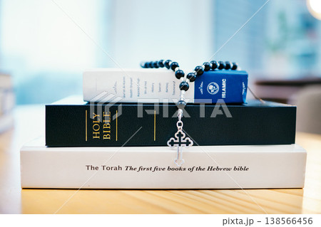 Books, stack and closeup on table for faith, Abrahamic religion or rosary with crucifix for study in home. Knowledge, holy spirit and education with cross for Jesus, Muhammad or Moses with solidarity Books, stack and closeup on table for faith, Abrahamic religion or rosary with crucifix for study in home. Knowledge, holy spirit and education with cross for Jesus, Muhammad or Moses with solidarity 138566456