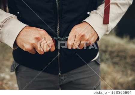 Hands, backpack strap and person hiking in nature on holiday, vacation and travel. Closeup, trekking and fasten clasp or adjust outdoor in forest, woods and countryside in preparation for adventure 138566694