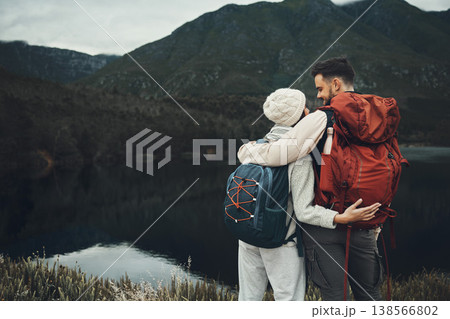 Hiking, couple and hug by a lake with camping and trekking together with love and back. Mountain, holiday and travel in the morning with a happy woman and man on adventure in nature with a smile 138566802