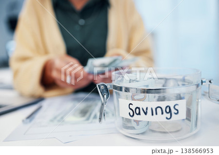Woman, jar and savings for money, investment or growth in finance, profit or expenses on desk at home. Female person counting cash, bills or paper notes in financial freedom or interest in container Woman, jar and savings for money, investment or growth in finance, profit or expenses on desk at home. Female person counting cash, bills or paper notes in financial freedom or interest in container 138566953