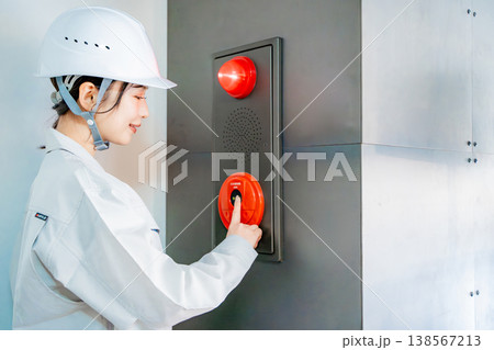 自動火災報知設備の点検をする作業着の女性 138567213