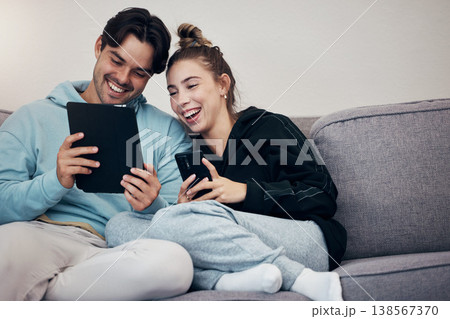 Couple, phone and tablet with relax on sofa for social media, internet scroll and funny meme with laugh. People, man or woman on couch with smartphone and touchscreen for technology and web streaming 138567370