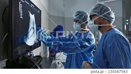 Surgery, x ray and a team of doctors in the hospital for an operation or procedure to remove a tumor. Healthcare, medical teamwork and a surgeon looking at a screen with a medicine professional Surgery, x ray and a team of doctors in the hospital for an operation or procedure to remove a tumor. Healthcare, medical teamwork and a surgeon looking at a screen with a medicine professional 138567563