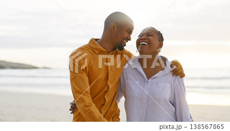 African couple, beach and arm for walk with love in outdoor for quality time on vacation. Happiness, man and women with bonding with ocean for travel or holiday to relax are cheerful together. African couple, beach and arm for walk with love in outdoor for quality time on vacation. Happiness, man and women with bonding with ocean for travel or holiday to relax are cheerful together. 138567865