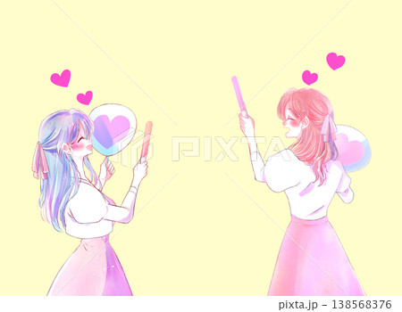 うちわとサイリウムを持って推し活をする女性2人 ピンク色 リボン うちわとサイリウムを持って推し活をする女性2人 ピンク色 リボン 138568376
