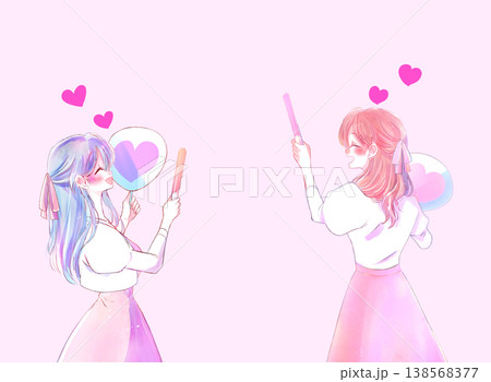 うちわとサイリウムを持って推し活をする女性2人 ピンク色 リボン うちわとサイリウムを持って推し活をする女性2人 ピンク色 リボン 138568377