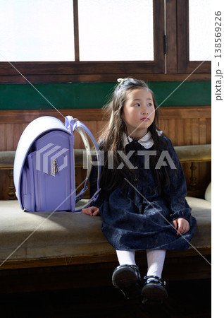 ランドセルとソファに座る日本人の女の子 138569226