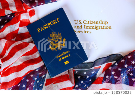 American passport is on table with an American flag scarf nearby are words U.S. Citizenship Immigration Services. American passport is on table with an American flag scarf nearby are words U.S. Citizenship Immigration Services. 138570025