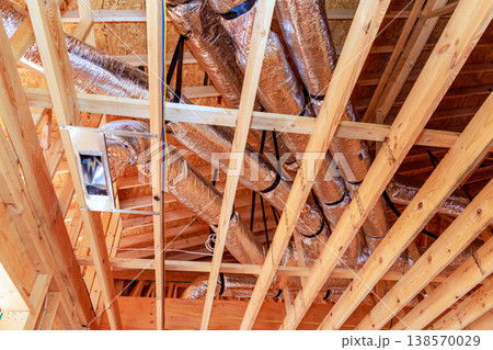 Ductwork with open wooden structure of house being built in suburban area during HVAC system Ductwork with open wooden structure of house being built in suburban area during HVAC system 138570029