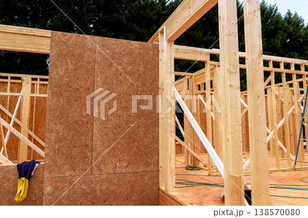 Workers are constructing house frame with wooden beams materials at construction site 138570080
