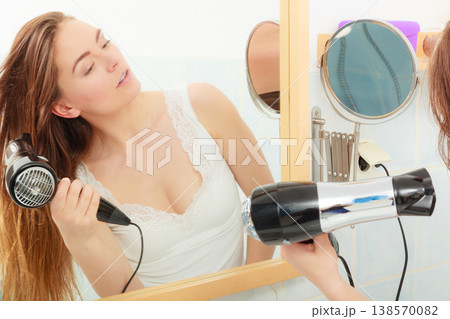 long haired woman drying hair in bathroom long haired woman drying hair in bathroom 138570082