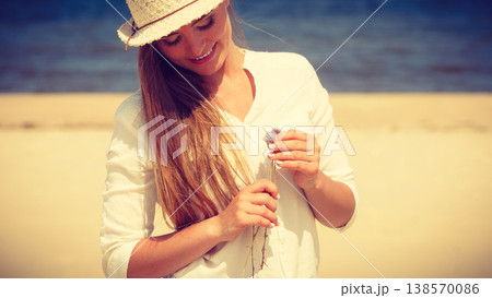 Smiling girl with flower on beach Smiling girl with flower on beach 138570086