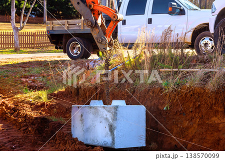 Excavator machine is lifting concrete block to place retaining walls at construction site Excavator machine is lifting concrete block to place retaining walls at construction site 138570099