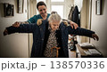Nursing home worker assisting a senior woman with clothing in a room. Gentle movement and attention. Concept of caregiving and wellbeing. 138570336