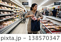 Indian woman shopper taking product without payment in store aisle. Concept of economic struggle and retail crime. 138570347