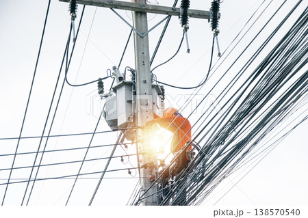 An electrician is working on a power pole. An electrician is working on a power pole. 138570540