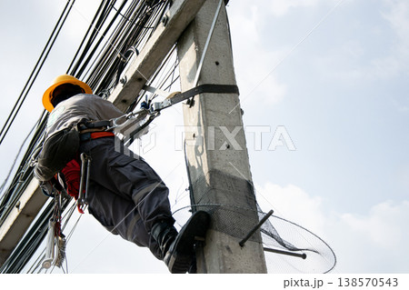 Electricians work on utility poles with safety as their top priority. Electricians work on utility poles with safety as their top priority. 138570543